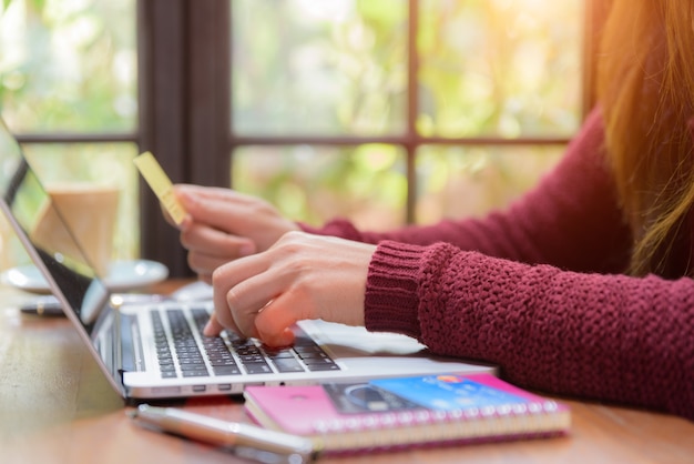 Kobieta wręcza trzymać kredytową kartę i używać laptop dla online zakupy.