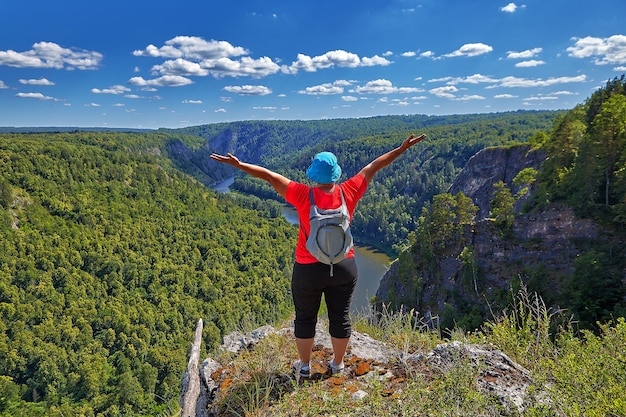 Kobieta Wspięła Się Na Szczyt Góry, Wędrując, Raduje Się Ze Swojego Zwycięstwa, Unosząc Ręce.