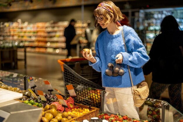 Kobieta wybiera owoce w supermarkecie