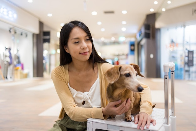 Kobieta wychodzi z dachshundem w centrum handlowym.