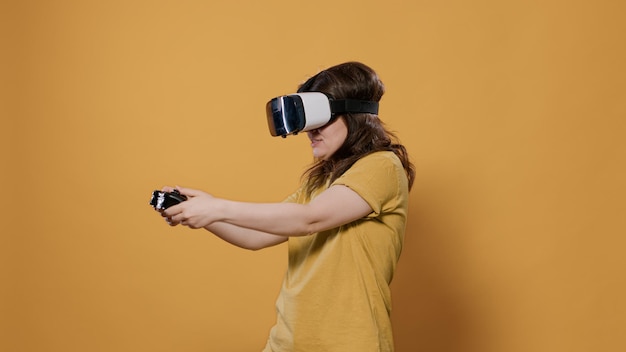 Kobieta Wygrywająca Trudną Grę Poziomu Za Pomocą Gogli Vr I Kontrolera Konsoli W Studio. Dziewczyna Gracza, Która Ma Intensywne Doświadczenia Z Wirtualną Rzeczywistością, Patrząc Na Otaczające środowisko 3d.