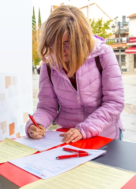 Kobieta wypełniająca formularz na ulicy Koncepcja petycji podpisu