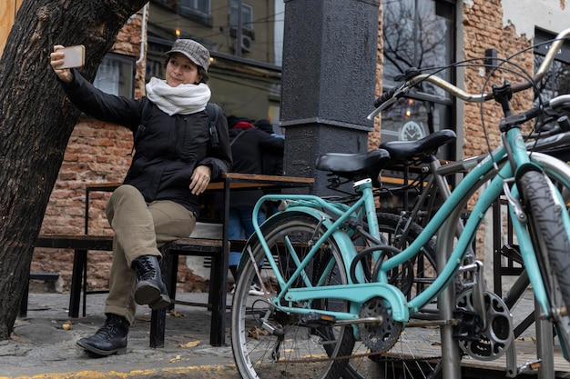Kobieta z Ameryki Łacińskiej z telefonem komórkowym na ulicach Buenos Aires obok roweru