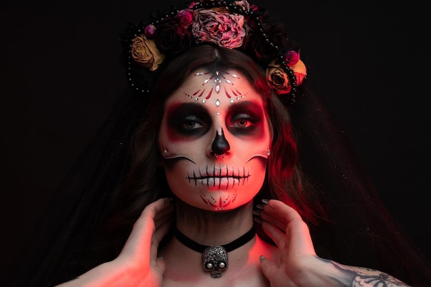Kobieta z artystycznym upiornym makijażem i świeżymi kwiatami na głowie gotowa na halloween