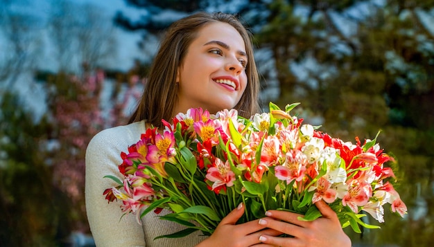 Zdjęcie kobieta z bukietem kwiatów koncepcja wakacji wiosennych kwiaty dziewczyny wiosna na świeżym powietrzu wiosna