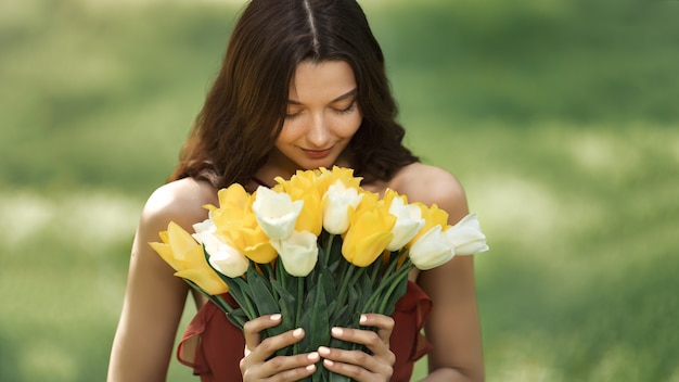 Zdjęcie kobieta z bukietem wiosennych kwiatów na zewnątrz