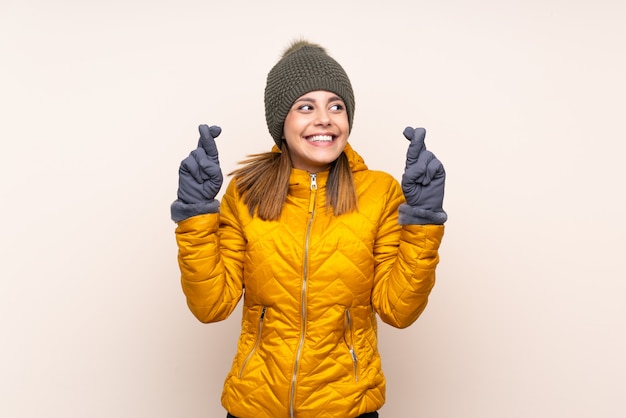 Kobieta z czapka zimowa na ścianie z palcami przekraczania