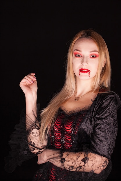 Kobieta z czerwoną sukienką wampira na halloween. Tajemnicza kobieta.