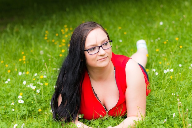 Zdjęcie kobieta z długimi włosami leżąca na trawiastym polu