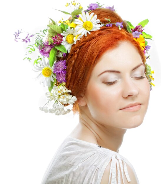 Kobieta z dużą fryzurą i kwiatami we włosach