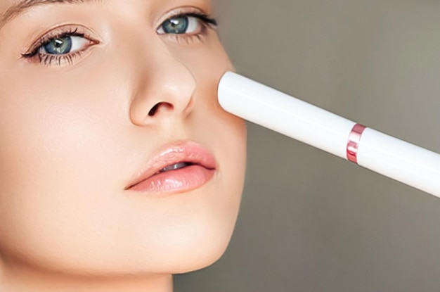 Kobieta z kosmetykami przeciwstarzeniowymi i zabiegami upiększającymi za pomocą urządzenia laserowego do resurfacingu skóry jako procedury odmładzania i rutynowej pielęgnacji skóry