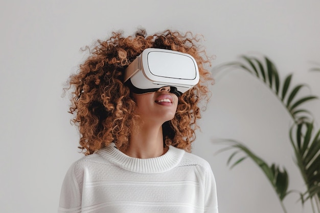 Kobieta z kręconymi włosami oglądająca się w okularze wirtualnej rzeczywistości w białym pokoju