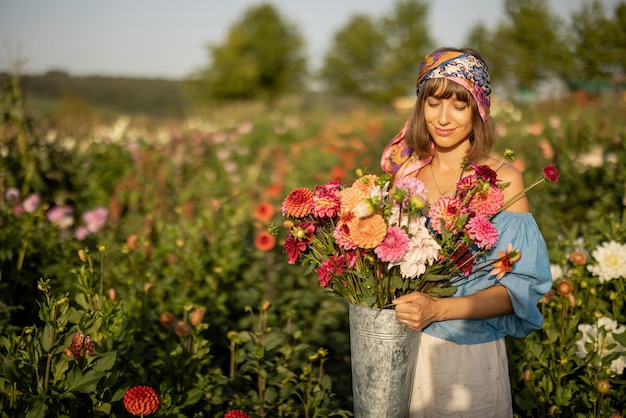 Kobieta z kwiatami na farmie dalii na zewnątrz