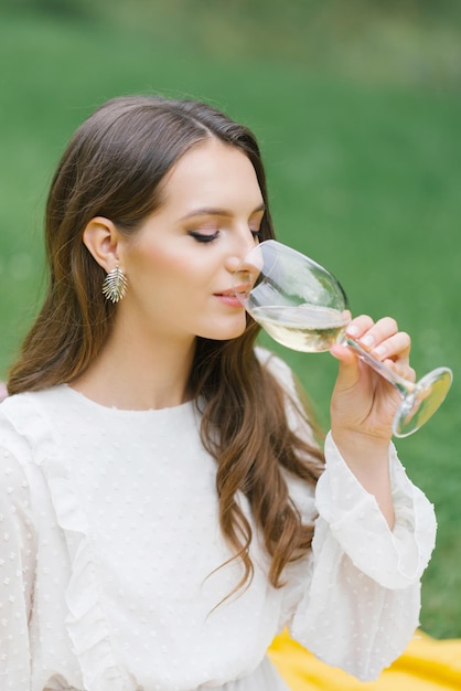 Kobieta z lampką wina marzy, szczęśliwa dziewczyna pije wina
