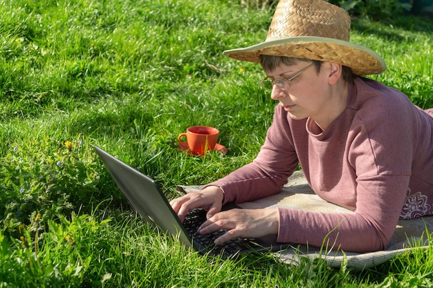 Kobieta z laptopem na wiosennej łące Idea efektywnego zarządzania biznesem w przyrodzie