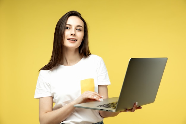 kobieta z laptopem na żółtym tle