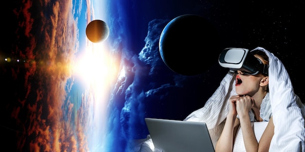 Kobieta z laptopem oczarowana wirtualną rzeczywistością. Różne środki przekazu
