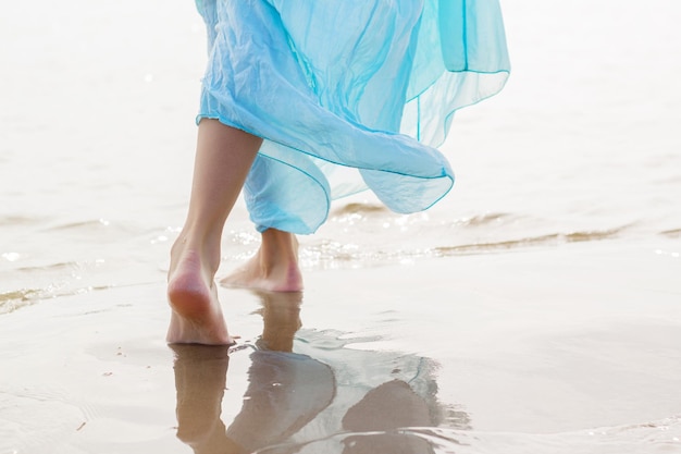 Kobieta z niebieską spódnicą spaceru na plaży