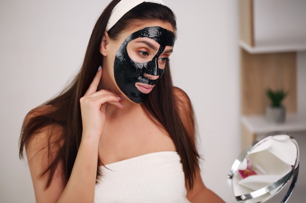 Kobieta z oczyszczającą peel-off czarną maską