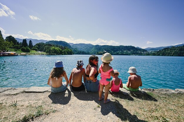 Kobieta z pięciorgiem dzieci siedzi na molo z widokiem na piękne jezioro Bled Słowenia Matka wielu dzieci