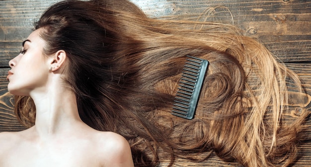 Kobieta z pięknymi długimi włosami na drewnianym tle Piękna kobieta farbująca włosy Długie włosy Moda