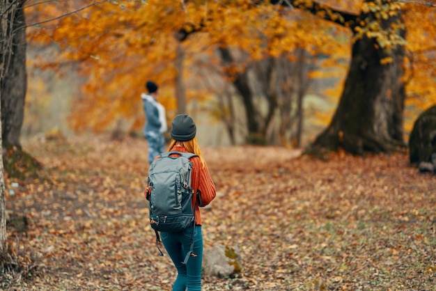 Kobieta z plecakiem spaceruje w lesie jesienią w krajobrazie drzew model przechodniów