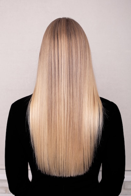 Zdjęcie kobieta z powrotem długie proste blond włosy w salonie fryzjerskim