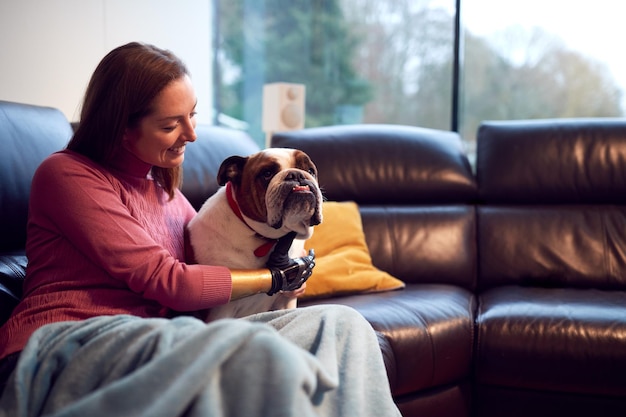 Kobieta z protezą ręki i dłoni w domu z psem