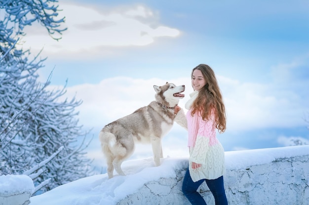 Kobieta Z Psem Husky Spacerująca Po Ośnieżonych Górach Zimą