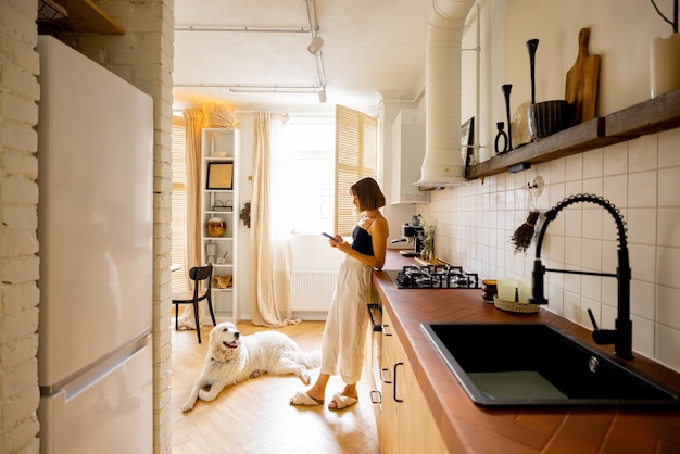 Kobieta z psem w nowoczesnej i stylowej kuchni