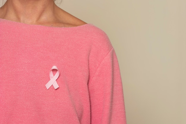 Kobieta z różową wstążką na różowej koszuli dla świadomości raka piersi