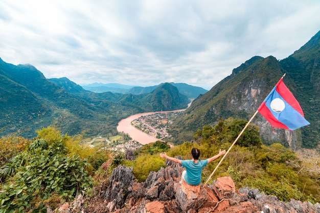 Kobieta z rozpostartymi ramionami zdobywca szczytu góry w Nong Khiaw Nam Ou River valley Laos dojrzałych ludzi podróżujących millenials koncepcja podróży w Azji Południowo-Wschodniej