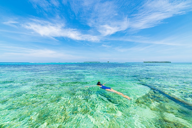 Kobieta z rurką na Karaibach na rafie koralowej tropikalnej turkusowej wodzie.