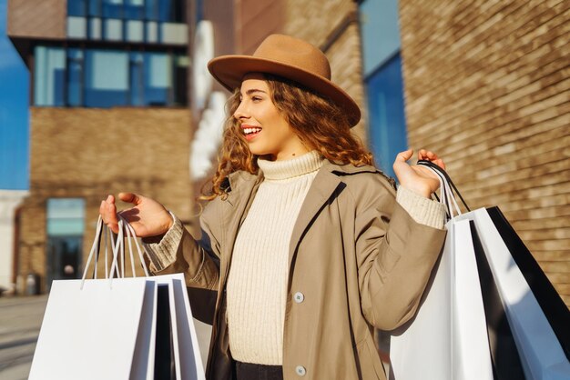Kobieta z torbami na zakupy w pobliżu centrum handlowego Konsumencja kupuje zakupy styl życia koncepcja sprzedaży