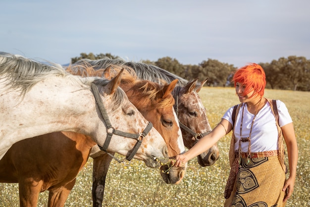 Kobieta z trzema końmi na wsi