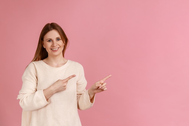 Kobieta z uśmiechem wskazującym palcem, zastanawiająca się nad pustym miejscem na reklamę