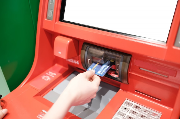 kobieta za pomocą karty kredytowej, aby wypłacić pieniądze z Atm Machine.