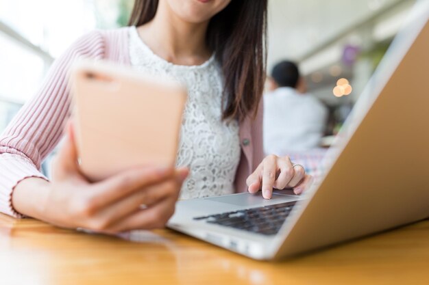 Kobieta za pomocą laptopa i telefonu komórkowego