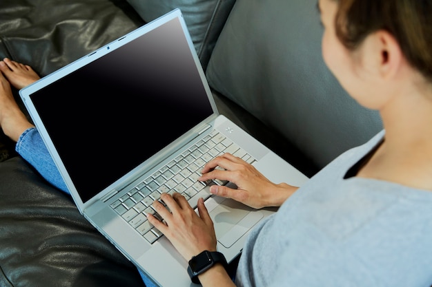 Kobieta za pomocą laptopa z pustym ekranem w domu