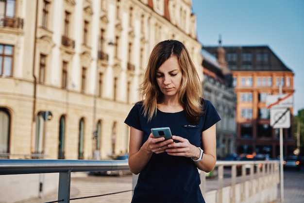 Kobieta za pomocą smartfona na ulicy miasta