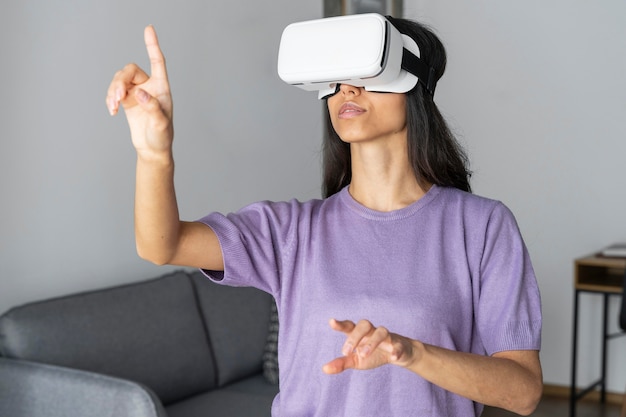 Zdjęcie kobieta za pomocą zestawu słuchawkowego wirtualnej rzeczywistości w domu z laptopem