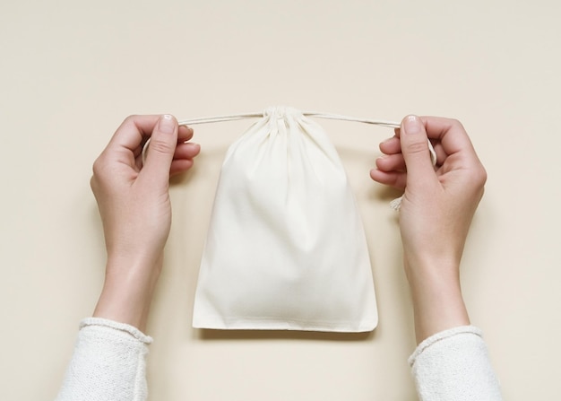 kobieta zamykająca małą bawełnianą torebkę ekologiczną białą bawełnianą torbę z krawatami