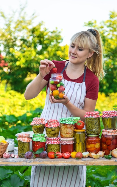 Kobieta ze słoikami konserwowanymi warzywami na zimę Selektywne skupienie