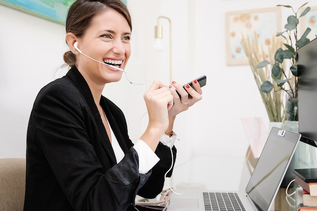 Kobieta ze słuchawkami odbiera telefon w miejscu pracy