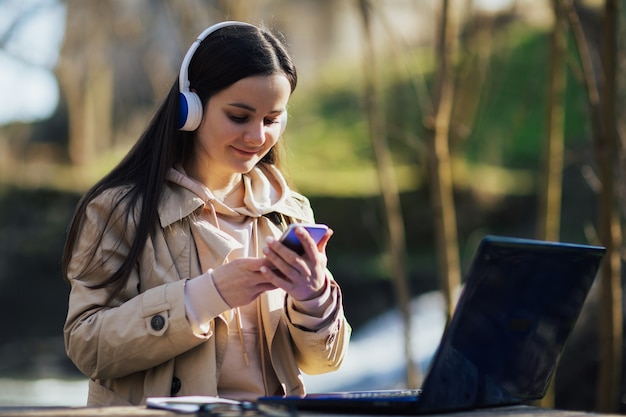 Kobieta Ze Słuchawkami Pracuje Na Laptopie I Używa Smartfona