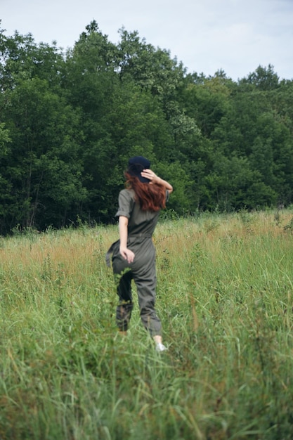 Kobieta zielony kombinezon spacer wysokiej trawy pole widok z tyłu