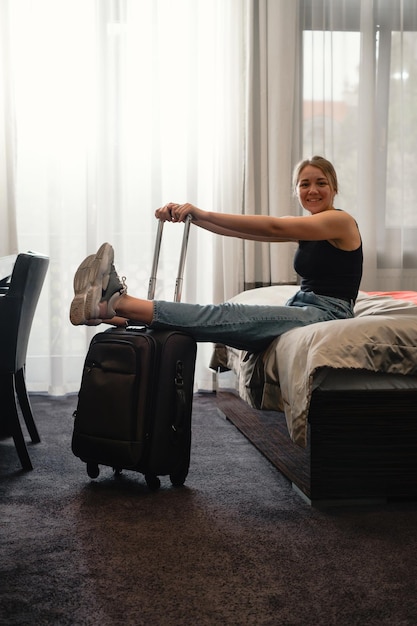 Kobieta zmęczona po długiej podróży odpoczywa w apartamencie hotelowym