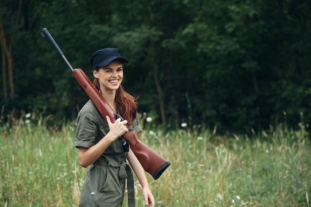 Kobieta żołnierz Wesoły uśmiech shotgun na ramieniu zielonej podróży kombinezon czarna czapka