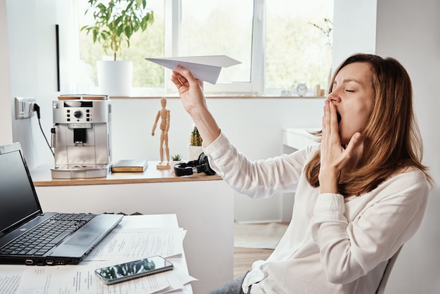 Kobieta Zwleka W Miejscu Pracy Freelancer Na Zdalnej Pracy W Domowym Biurze Niezmotywowana Zmęczona Kobieta Bawi Się Papierowym Zwykłym Leniwym Pracownikiem Biurowym