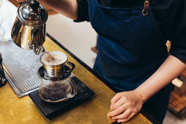 Kobiety Barista robią kroplówkę warzoną, przefiltrowaną kawę